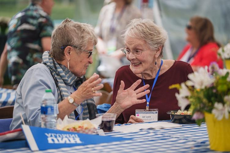 Two women having a conversation at a table during reunion