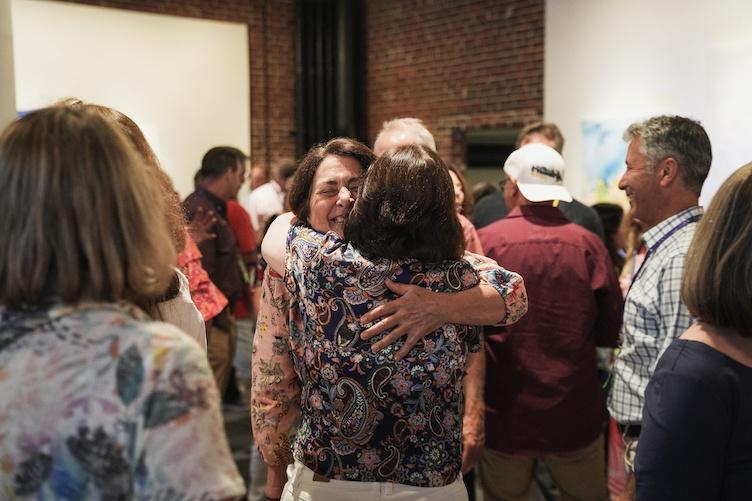 Two attendees hug at reunion